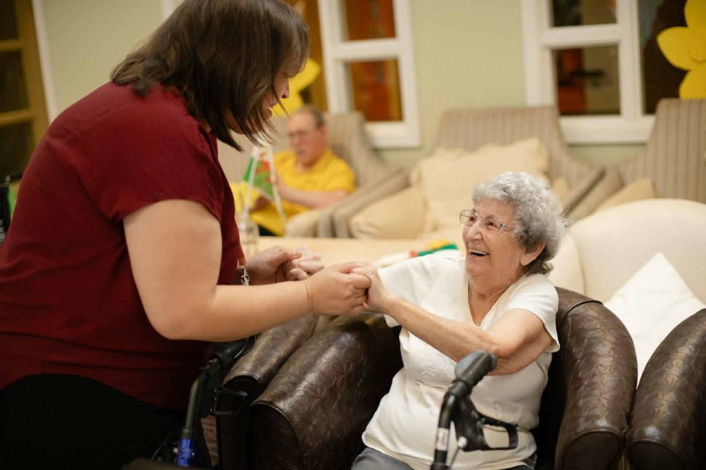 An aide helping an older woman in a wheelchair