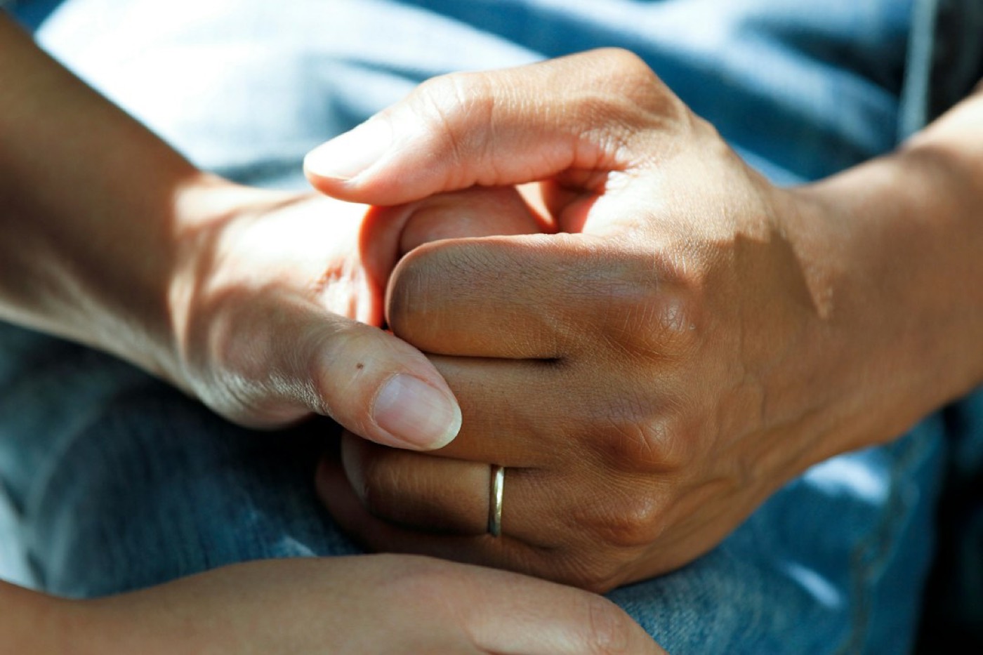 A caregiver holding an older person's hands